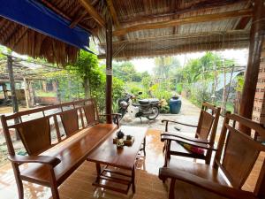 uma sala de jantar com mesa e cadeiras e uma moto em Vong Nguyet Homestay - Entire Bungalow 36m2 em Tây Ninh