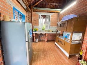 eine Küche mit einem Kühlschrank und einer Ziegelwand in der Unterkunft Vong Nguyet Homestay - Entire Bungalow 36m2 in Tây Ninh