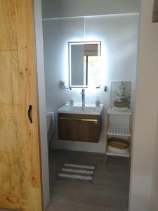 La salle de bains est pourvue d'un lavabo et d'un miroir. dans l'établissement Airport Green Studio, à Santiago Este