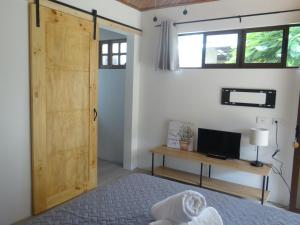 een slaapkamer met een houten deur, een bed en een bureau bij Airport Green Studio in Santiago Este