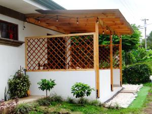 a pergola on the side of a house at Airport Green Studio in Santiago Este