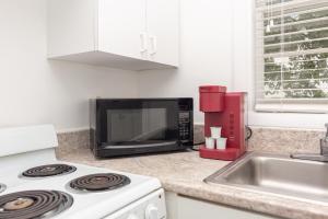 a kitchen with a microwave and a stove and a sink at Studio Fort Lauderdale - 5 minutes walk to Las Olas Beach in Fort Lauderdale