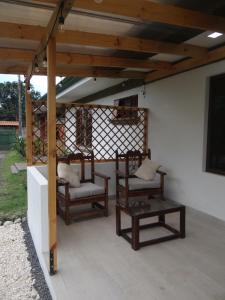 twee stoelen en een tafel onder een pergola bij Airport Green Studio in Santiago Este