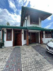 a house with a car parked in front of it at Rusty Bunk Villa in Kandy +18 photos