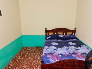 a bedroom with a bed with a floral bedspread at Rainbow House in León