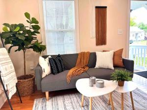 ein Wohnzimmer mit einem grauen Sofa und einem Tisch in der Unterkunft Cozy Boho Home Close to Short North/OSU Campus/Downtown in Columbus
