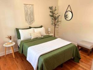 ein Schlafzimmer mit einem grünen und weißen Bett und einer Uhr in der Unterkunft Cozy Boho Home Close to Short North/OSU Campus/Downtown in Columbus