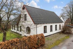 a white house with a black roof at Bed & Breakfast “Den Gamle Lade I Hejls” in Hejls