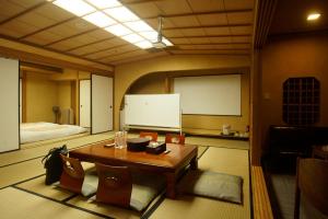 einen Tagungsraum mit einem Tisch und einem Whiteboard in der Unterkunft 熱海の隠れ里 in Atami