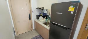 a black refrigerator in a kitchen with a sink at Cozy and Beautiful Condo on Riverside Phnom Penh in Phnom Penh