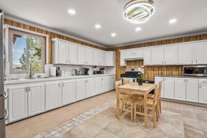 a kitchen with white cabinets and a wooden table at Luxury 6BR Retreat Fast WIFI, Dedicated Workspaces in Hesperia