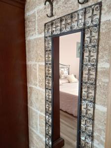 een spiegel in de hoek van een kamer met een bed bij ONIRO Specchia in Specchia