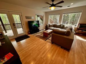 sala de estar con sofá y TV de pantalla plana en Guest Suite with Hot Tub - Edge of the Wild en Eagle River