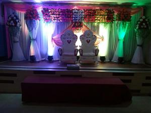 a room with a table with two chairs and curtains at Hotel Ravi Mayur International in Chitradurga