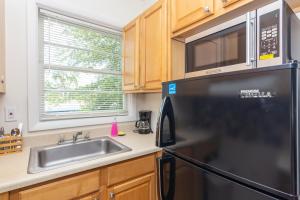 a kitchen with a black refrigerator and a sink at Las Olas Studio - 5 minutes from Las Olas Beach in Fort Lauderdale