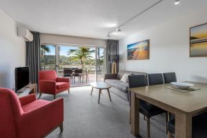 Club Wyndham Coffs Harbour Terraces في كوفس هاربور: غرفة معيشة مع أريكة وطاولة وكراسي