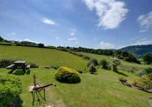 a green field with a picnic table and a bench at Carnedd Llywelyn in Llanrwst