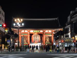 a building with a chinese sign on a street at night at Vessel Inn Asakusa Tsukuba Express in Tokyo