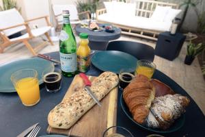 uma mesa com pão e garrafas de vinho e bebidas em Classy 1 BR Apt w Private Balcony By Sea N' Rent em Tel Aviv
