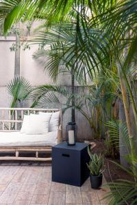 Classy 1 BR Apt w Private Balcony By Sea N' Rent في تل أبيب: غرفة نوم بسرير وطاولة بالنباتات