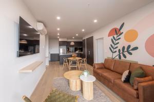 uma sala de estar com um sofá e uma mesa em Grow at Goodwood em Adelaide