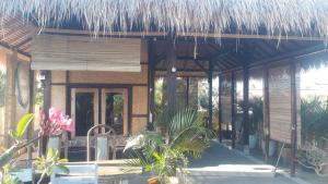 a house with a straw roof and some plants at kunci rumah in Sorongjukung