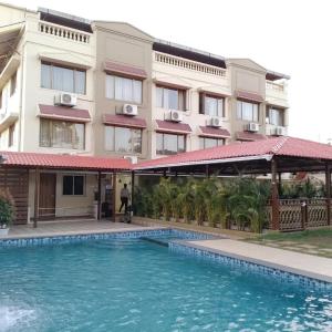 un hotel con piscina frente a un edificio en Mountview Resort, en Lonavala
