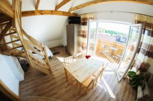 Habitación con mesa, sillas y escalera. en Mazurski Zakątek-Apartamenty en Mikołajki