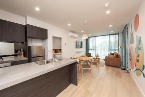 a kitchen and living room with a table and a dining room at Grow at Goodwood in Adelaide