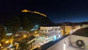 a view of a city at night with a mountain in the background at GIORGIO LUXURY LOFT WITH AMAZING VIEW Of NAFPLIO in Nafplio