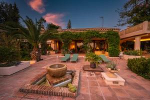 a house with a courtyard with a fountain at Character filled villa with mature garden in Marbella