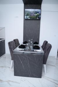 a kitchen with a counter with two chairs and a table at ITACA apartman Krupanj in Krupanj