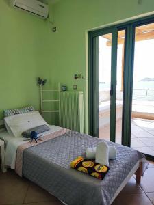 een slaapkamer met een bed en een groot raam bij Seagulls - Within walking distance from sea! in Petriaí