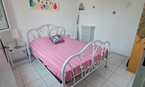 1 dormitorio con 1 cama con manta rosa en La maison coquillage, en Le Barcarès