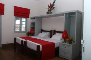 a bedroom with a large bed with a red blanket at Khalid's Guest House in Galle