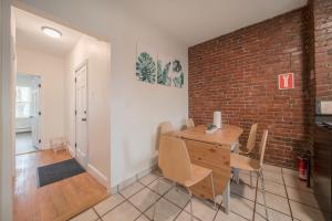 波士頓的住宿－2BR Apt in The Heart Of Boston near Boston Med，一间设有砖墙和桌椅的用餐室