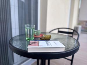 a glass table with a book and a cup and a book at Stay Thyme, 2 BRS apt, 5mins Nafplio, 10 mins beach in Nafplio