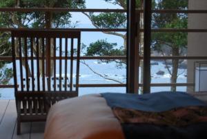 a bedroom with a bed and a large window at Oyado The Earth in Toba