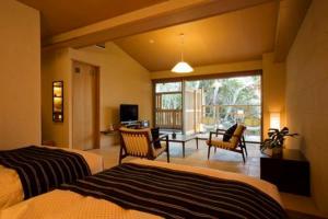 a bedroom with two beds and a living room with a patio at Oyado The Earth in Toba +97 photos