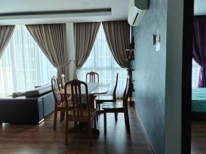 a dining room and living room with a table and chairs at Viva city Jazz3 Homestay Near Tabuan Jaya in Kuching