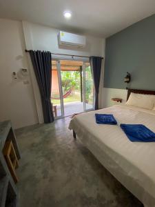 a bedroom with a bed and a sliding glass door at Zabit Bungalow in Ko Lanta