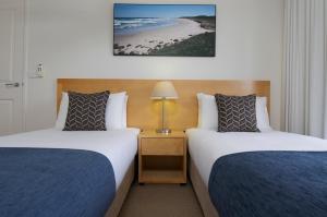 a hotel room with two beds and a beach at Club Wyndham Port Macquarie in Port Macquarie