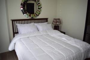 a white bed in a bedroom with a mirror at Consuelo Boracay Unit Rental in Boracay +27 photos