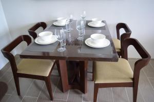 a wooden table with glasses and plates and chairs at Consuelo Boracay Unit Rental in Boracay