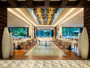 a restaurant with tables and chairs and large windows at Sofitel Bali Nusa Dua Beach Resort in Nusa Dua