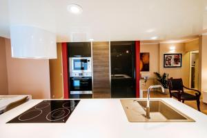 
a kitchen with a refrigerator, sink and a television at Suites One in Zadar
