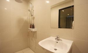 a bathroom with a sink and a shower with a mirror at Iksan 4 Seasons Hotel in Iksan