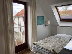 a small bedroom with a bed and a window at Ferienwohnung-Jim-Knopf-mit-Balkon-zwischen-Strand-Wald-Wiese-im-Suedosten-der-Insel-Ruegen in Gustow