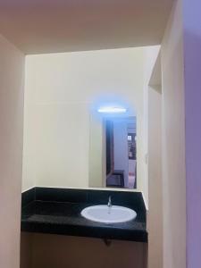 a bathroom with a sink and a mirror at Hotel Sunday - Townhouse Club Airport Trivandrum in Trivandrum