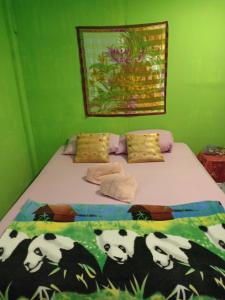 Un dormitorio con una cama con pandas. en Baanchaokoh Homestay en Kanchanaburi